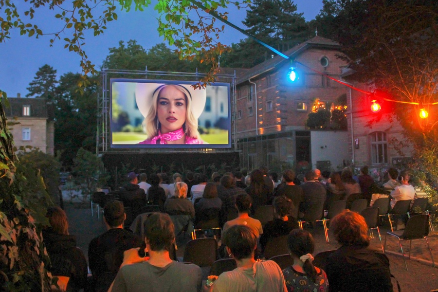 Central Open-Air Kino mit Besuchern vor Leinwand und Bürgerbräu-Gelände im Hintergrund